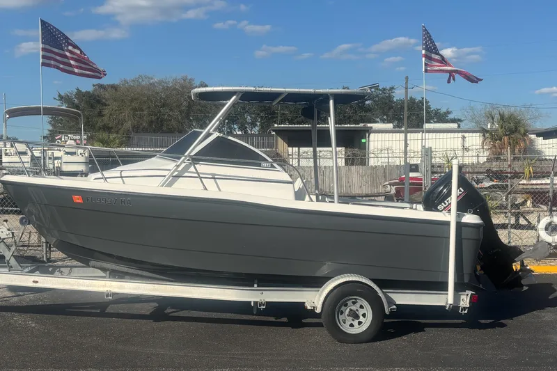 The Image of 1998 Bayliner Trophy Walkaround boat on trailer, American flags in background. - 1