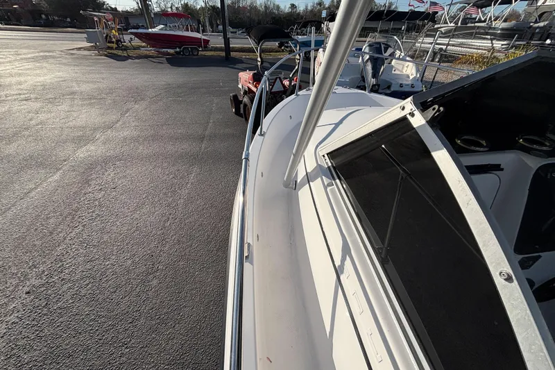 Slide: The Image of 1998 Bayliner Trophy Walkaround boat parked in a marina with other vessels. - 22