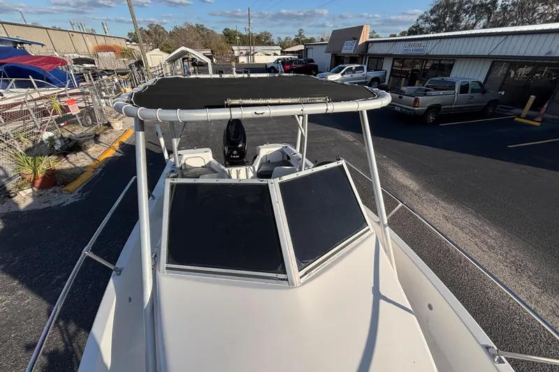 Slide: The Image of 1998 Bayliner Trophy Walkaround boat with canopy, parked in a marina lot. - 25