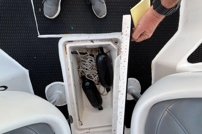 Slide: The Image of Open storage compartment on 1998 Bayliner Trophy Walkaround boat, containing ropes and fenders. - 28
