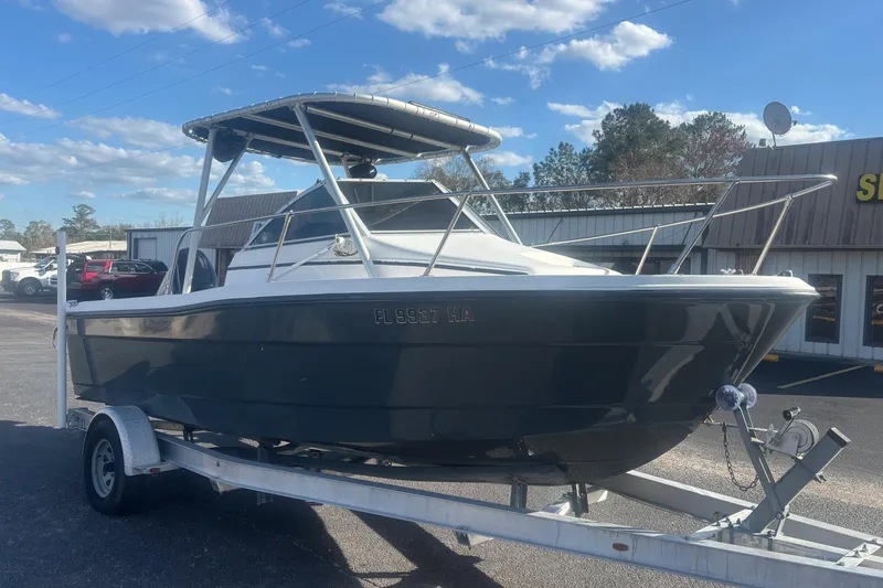 Slide: The Image of 1998 Bayliner Trophy Walkaround boat on trailer, parked outdoors under a clear sky. - 7