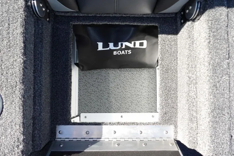 Slide: The Image of Interior view of 2026 Lund 1875 Renegade boat with carpeted flooring and storage compartment. - 17