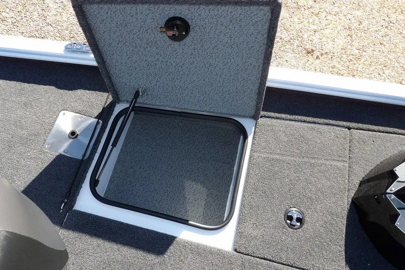Slide: The Image of 2026 Lund 1875 Renegade boat storage compartment with open hatch and carpeted interior. - 31