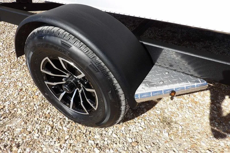Slide: The Image of 2026 Lund 1875 Renegade trailer wheel with black fender on gravel surface. - 45
