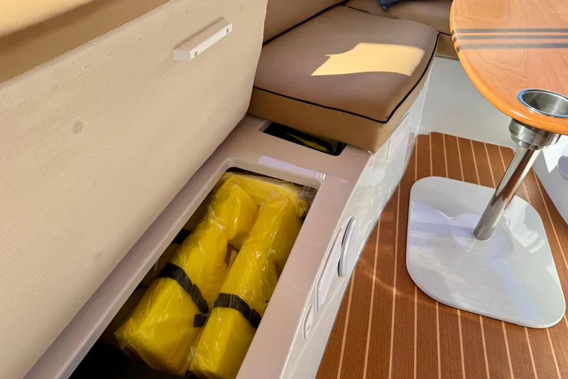Slide: The Image of 2022 Duffy Suncruiser 22 interior with storage compartment and yellow life jackets. - 17