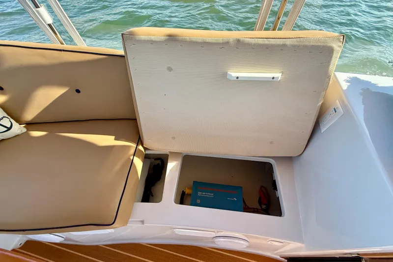 Slide: The Image of Open storage compartment on 2022 Duffy Suncruiser 22 boat with beige seating. - 18