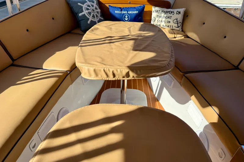 Slide: The Image of Interior of 2022 Duffy Suncruiser 22 with tan seating and nautical-themed pillows. - 23