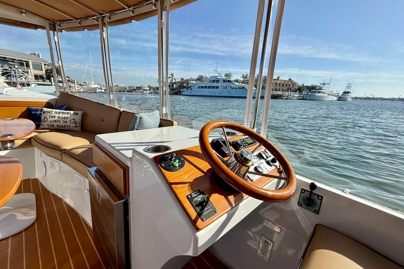 Slide: The Image of 2022 Duffy Suncruiser 22 interior with steering wheel, docked by waterfront. - 5