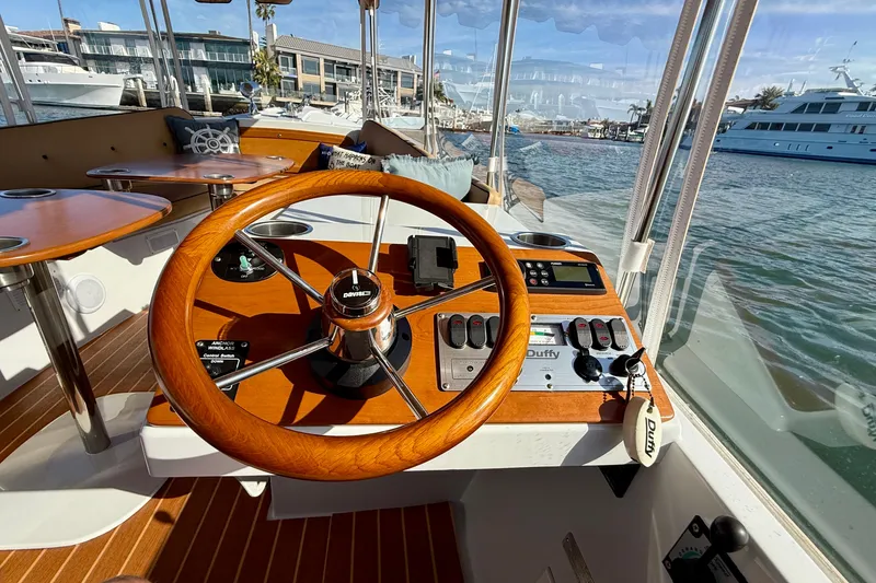 Slide: The Image of Interior view of 2022 Duffy Suncruiser 22 boat with wooden steering wheel and control panel. - 6