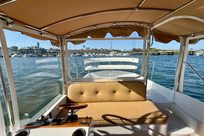 Slide: The Image of 2022 Duffy Suncruiser 22 boat interior with tan seating and waterfront view. - 8