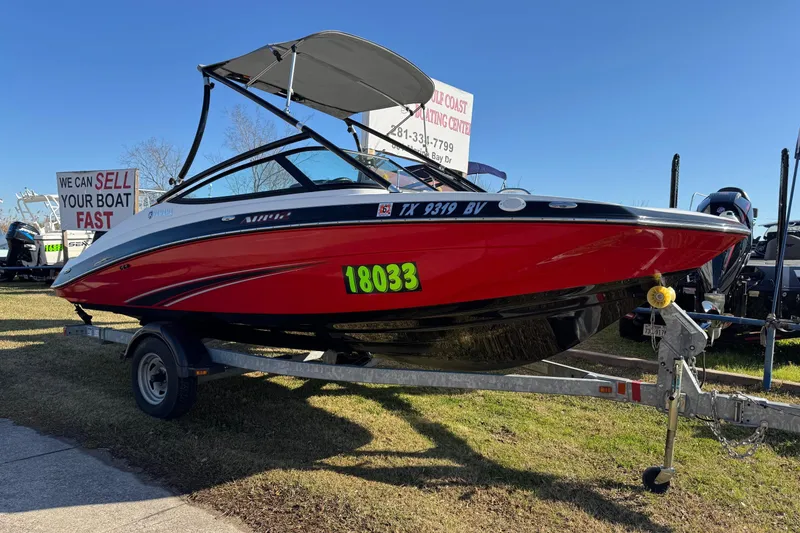 The Image of 2013 Yamaha Boats AR192 in red on trailer, displayed outdoors under clear blue sky. - 0