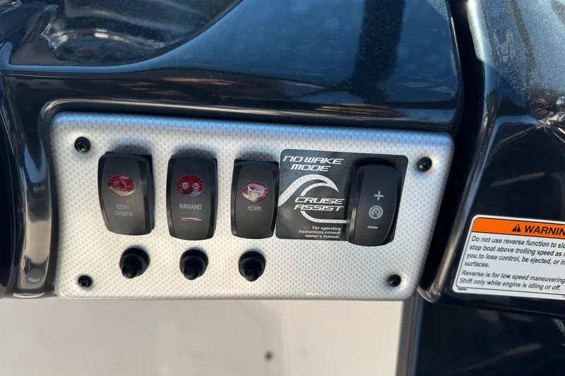 Slide: The Image of Control panel of 2013 Yamaha Boats AR192 featuring various switches and warning label. - 13