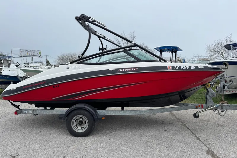 Slide: The Image of 2013 Yamaha Boats AR192, red and white, on a trailer in a parking lot. - 3
