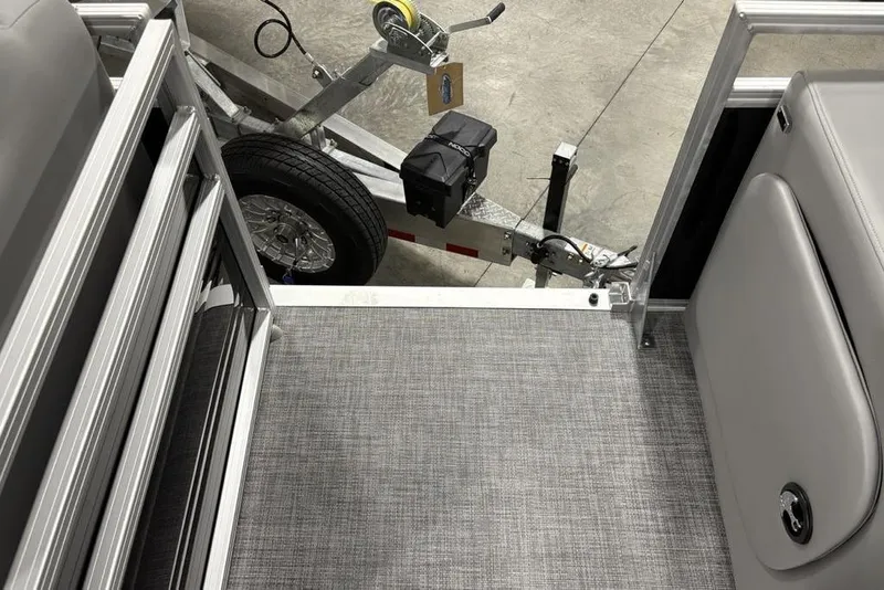 Slide: The Image of 2026 Sun Tracker SportFish 22 DLX interior with gray flooring and trailer view. - 16