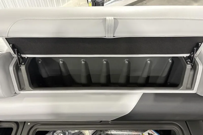 Slide: The Image of 2026 Sun Tracker SportFish 22 DLX storage compartment with open lid, showcasing interior space. - 2