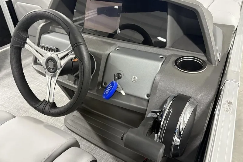 Slide: The Image of 2026 Sun Tracker SportFish 22 DLX dashboard with steering wheel and control panel. - 23