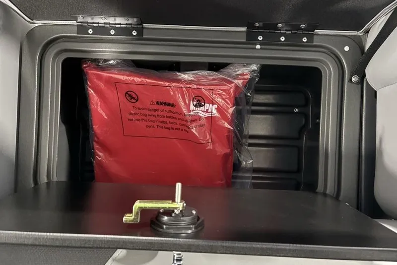 Slide: The Image of Storage compartment in 2026 Sun Tracker SportFish 22 DLX with safety warning label. - 25