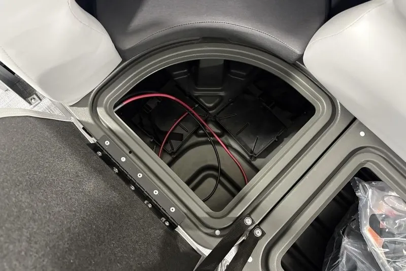 Slide: The Image of Storage compartment of 2026 Sun Tracker SportFish 22 DLX boat, featuring wiring and seating. - 3