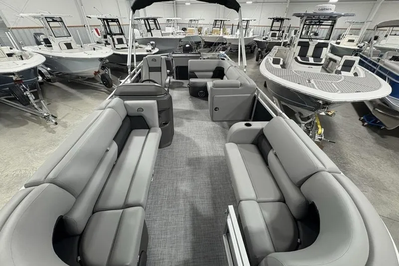 Slide: The Image of 2026 Sun Tracker SportFish 22 DLX pontoon boat interior with gray seating in showroom. - 39