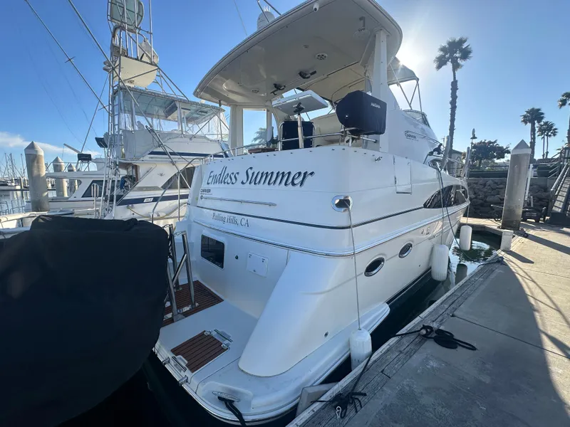 Slide: The Image of Carver 396 Motor Yacht 2004 docked, sunny day, palm trees in background. - 2