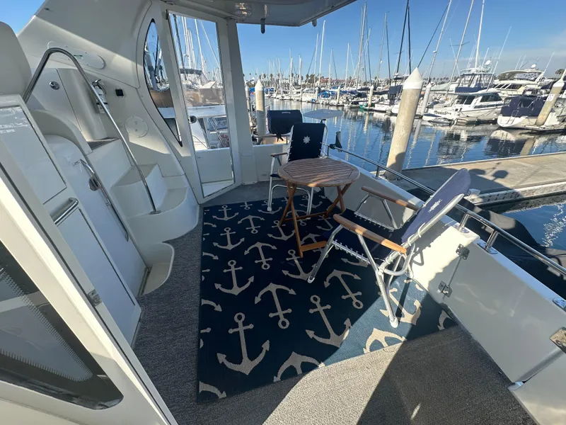 Slide: The Image of Interior of 2004 Carver 396 Yacht with anchor rug, table, and chair. - 5