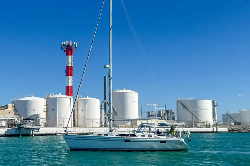 Slide: The Image of 2022 Catalina 385 sailboat docked in a sunny marina with palm trees. - 2