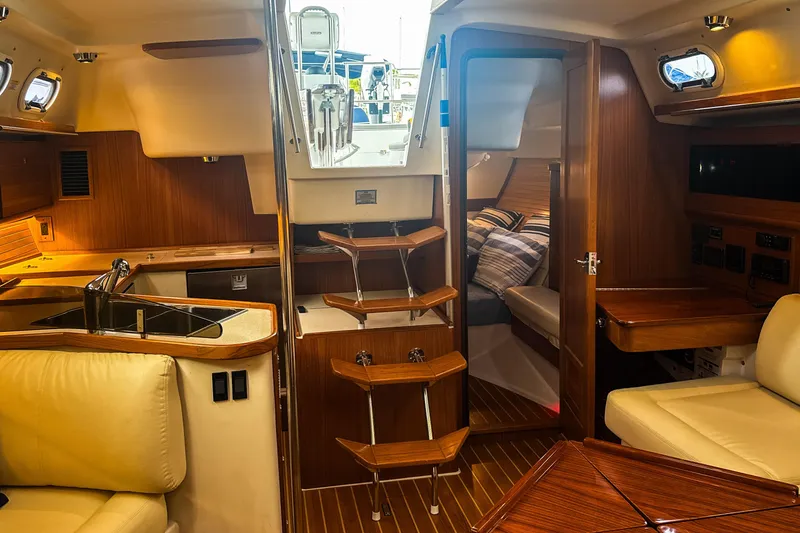 Slide: The Image of Cozy cabin interior of 2022 Catalina 385 sailboat with striped bedding and wooden accents. - 38