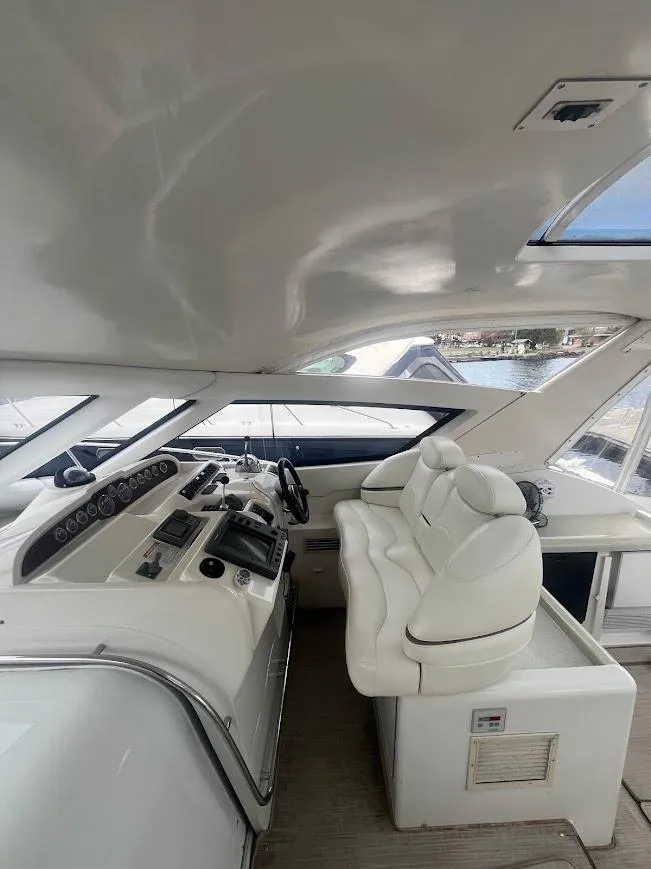 Slide: The Image of 2000 Carver 440 Hardtop Express yacht interior with white seating and control panel. - 10