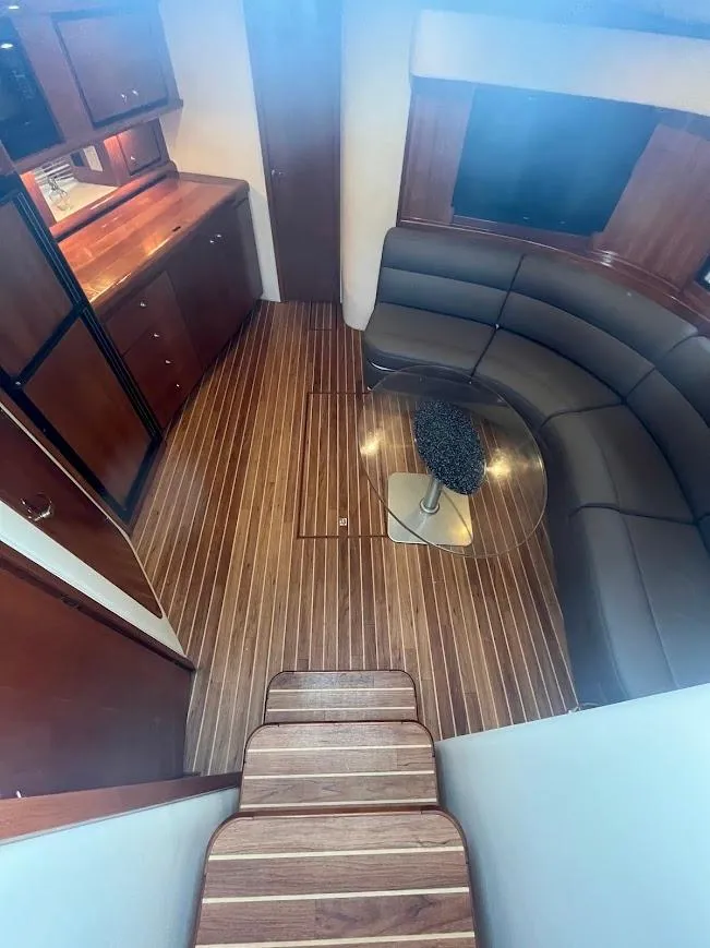 Slide: The Image of Interior of 2000 Carver 440 Hardtop Express with wood flooring and curved seating. - 13