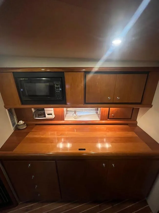 Slide: The Image of Interior of 2000 Carver 440 Hardtop Express with wooden cabinetry and built-in microwave. - 16