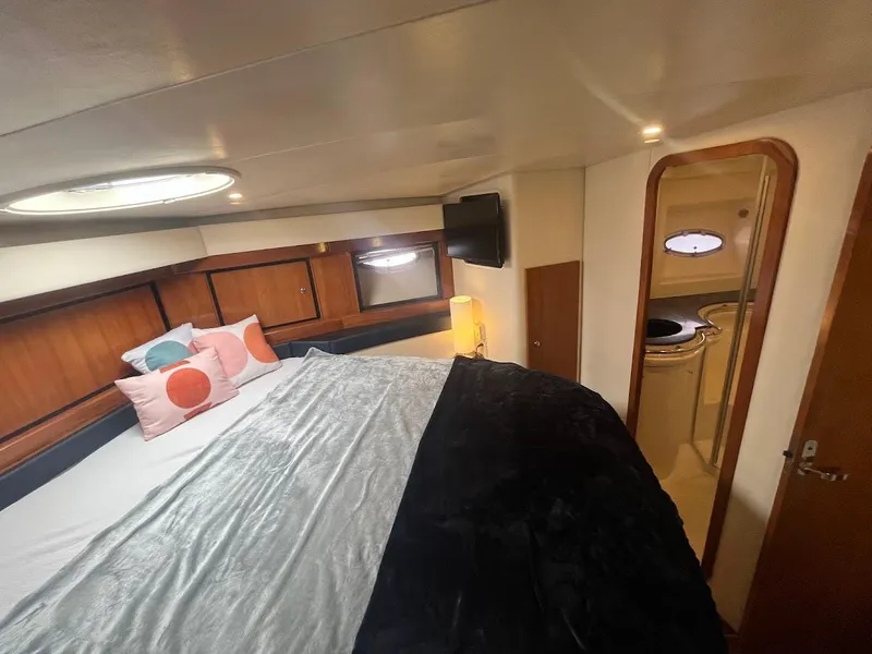 Slide: The Image of Cozy bedroom inside 2000 Carver 440 Hardtop Express yacht with modern decor and soft lighting. - 18