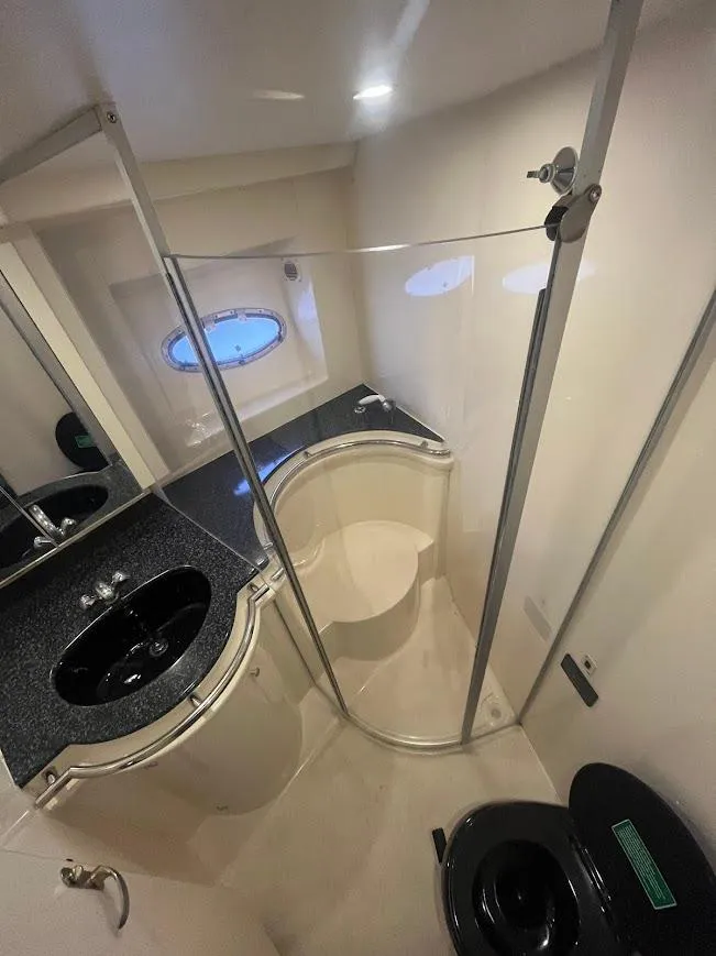 Slide: The Image of Bathroom interior of 2000 Carver 440 Hardtop Express yacht, featuring modern fixtures and porthole window. - 19
