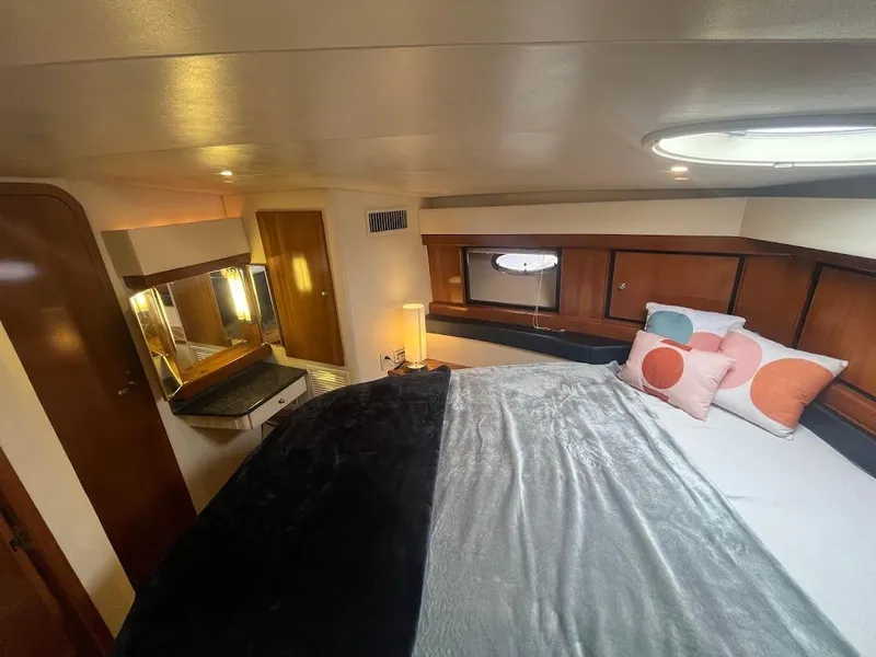 Slide: The Image of 2000 Carver 440 Hardtop Express cabin with bed, pillows, and vanity area. - 20