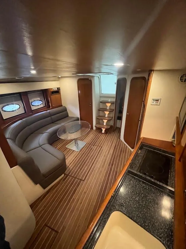 Slide: The Image of Interior of 2000 Carver 440 Hardtop Express yacht with modern seating and wooden flooring. - 22