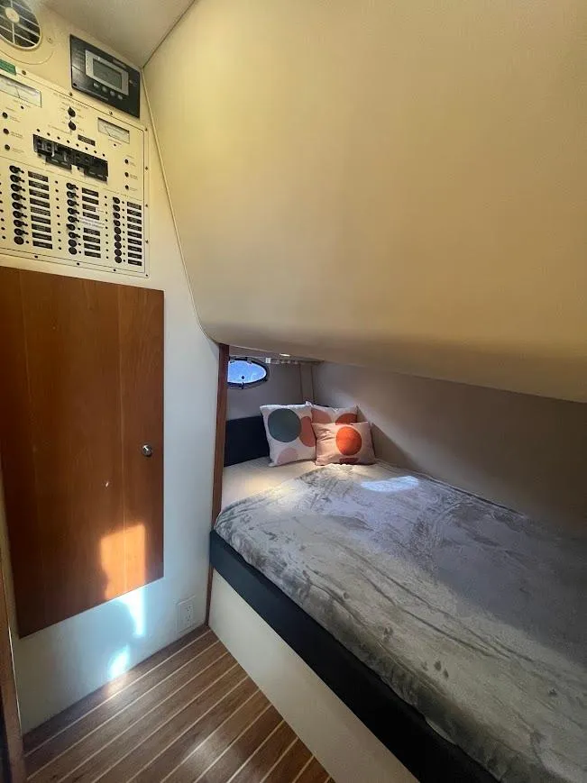 Slide: The Image of Cozy cabin interior of 2000 Carver 440 Hardtop Express with bed and control panel. - 23