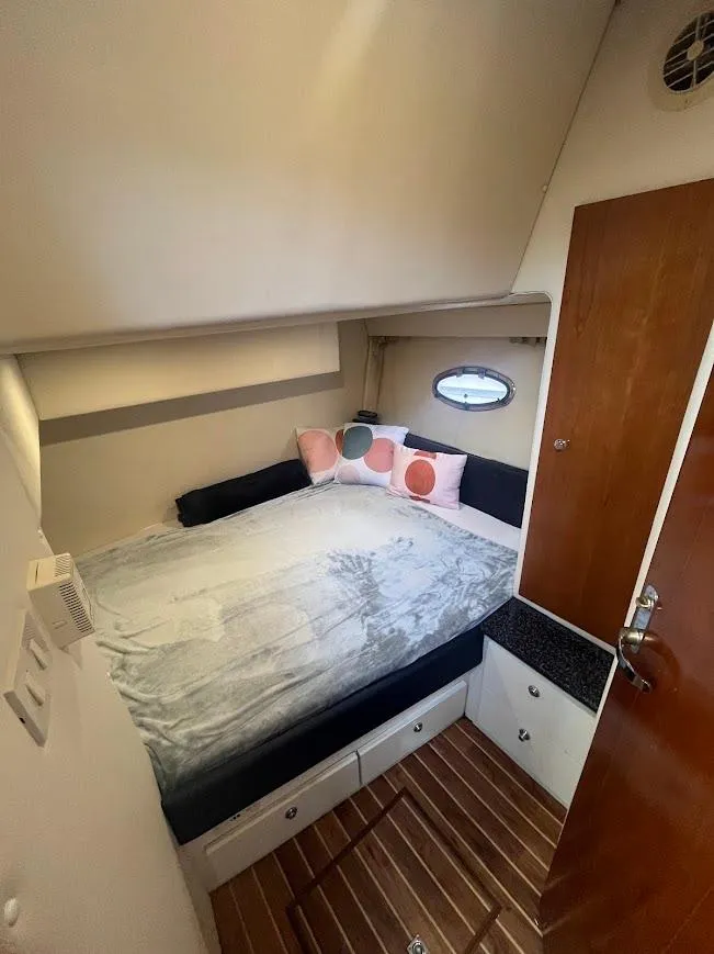 Slide: The Image of Cozy bedroom in 2000 Carver 440 Hardtop Express yacht with bed and porthole window. - 24