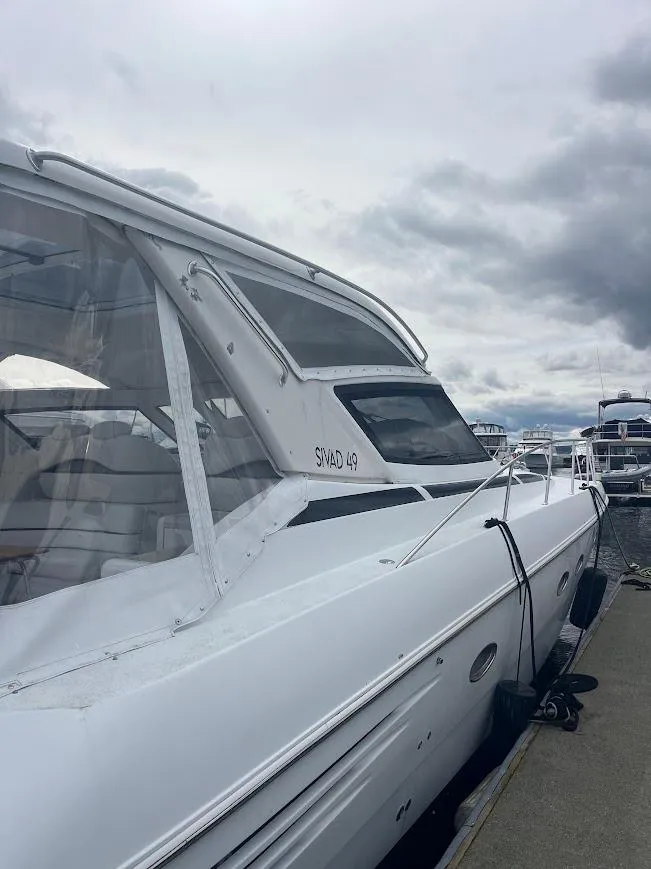 Slide: The Image of 2000 Carver 440 Hardtop Express yacht docked under cloudy skies. - 26