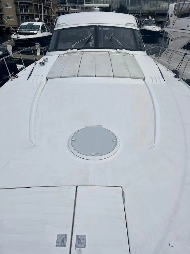 Slide: The Image of 2000 Carver 440 Hardtop Express yacht docked at marina, showcasing sleek design and spacious deck. - 27