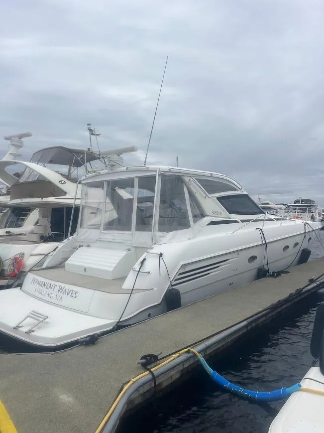 Slide: The Image of 2000 Carver 440 Hardtop Express yacht docked at marina under cloudy sky. - 3