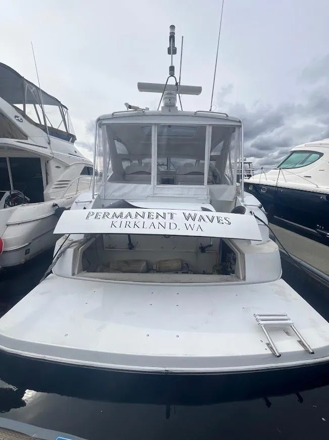 Slide: The Image of 2000 Carver 440 Hardtop Express yacht docked, rear view, "Permanent Waves" signage, Kirkland, WA. - 5