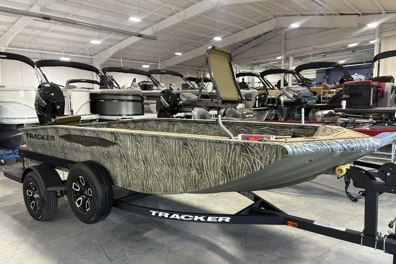 The Image of 2026 Tracker Grizzly 1650 T Prairie Wings Edition boat in showroom, camo design, on trailer. - 1
