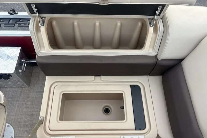 Slide: The Image of 2019 Sun Tracker Fishin' Barge 20 DLX storage compartments with open lids, showcasing interior space. - 12