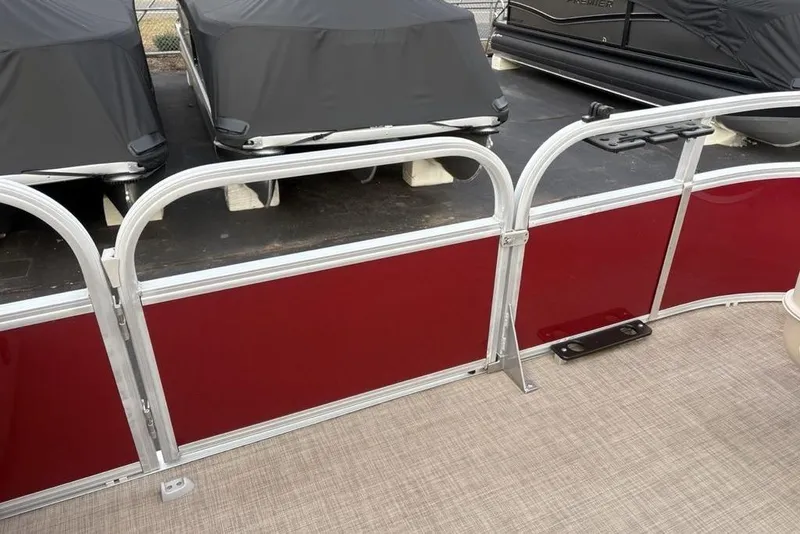 Slide: The Image of 2019 Sun Tracker Fishin' Barge 20 DLX with red paneling and covered boats in background. - 14
