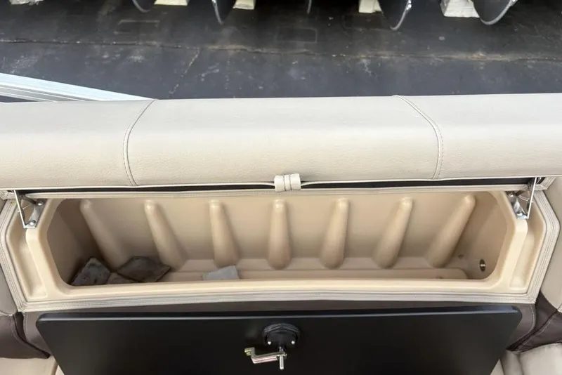 Slide: The Image of 2019 Sun Tracker Fishin' Barge 20 DLX storage compartment with beige cushioned lid. - 25