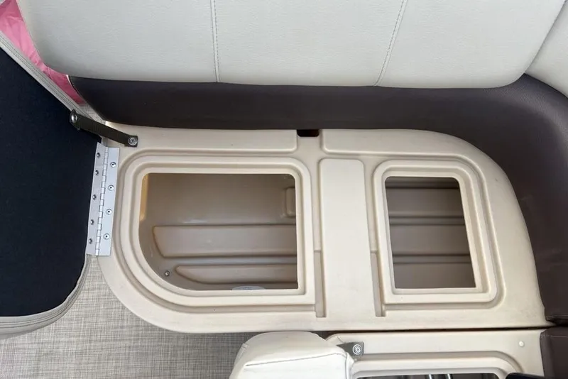 Slide: The Image of 2019 Sun Tracker Fishin' Barge 20 DLX storage compartment with open lid, showcasing interior space. - 27