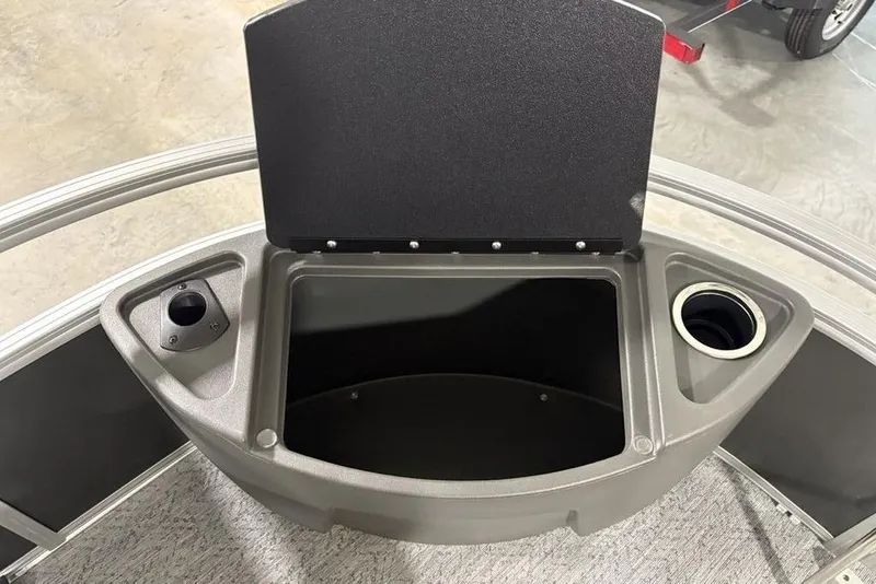 Slide: The Image of 2026 Sun Tracker Bass Buggy 18 DLX storage compartment with cup holders and open lid. - 9