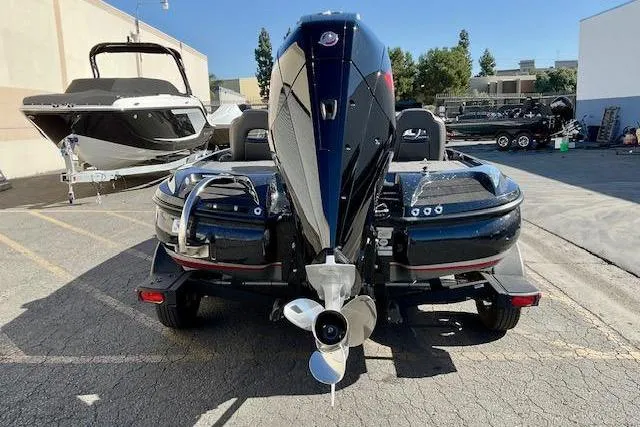 Slide: The Image of 2024 Nitro Z20 Pro boat, rear view, parked outdoors with motor and trailer. - 2