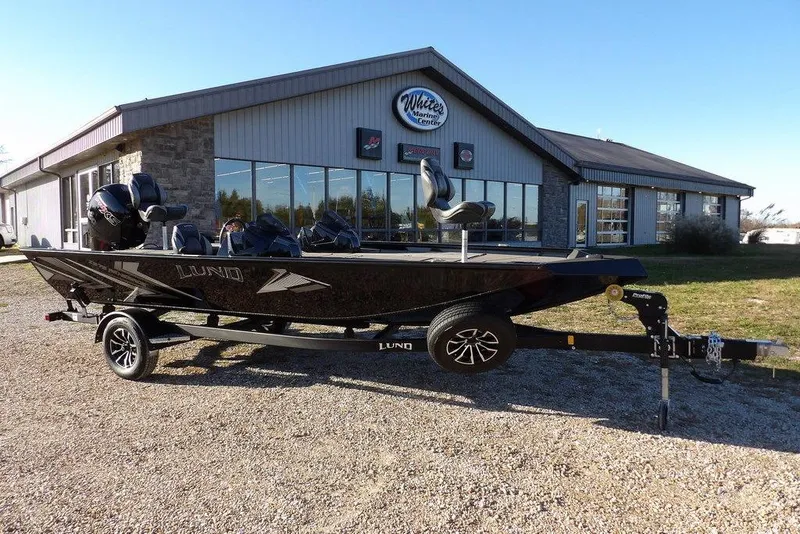 The Image of 2026 Lund 1975 Renegade boat on trailer outside marine center. - 1