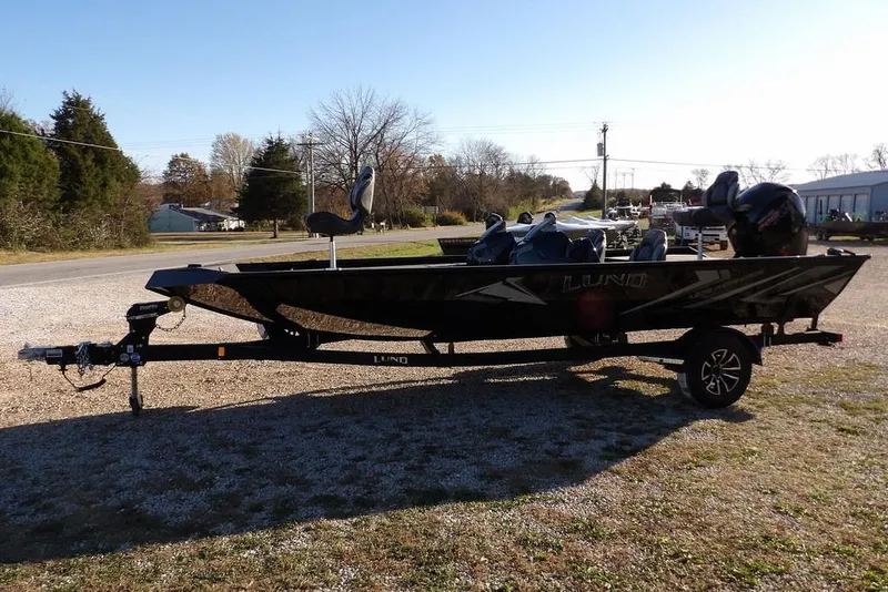 Slide: The Image of Lund 1975 Renegade 2026 fishing boat on trailer, parked outdoors. - 11
