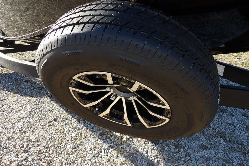 Slide: The Image of Close-up of a 2026 Lund 1975 Renegade tire on gravel surface. - 46